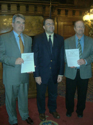 John Mitchell, Rep. Dante Santoni (bill sponsor) and Craig Gassmann posing with HB500 and HB501 signed by Governor Rendell.